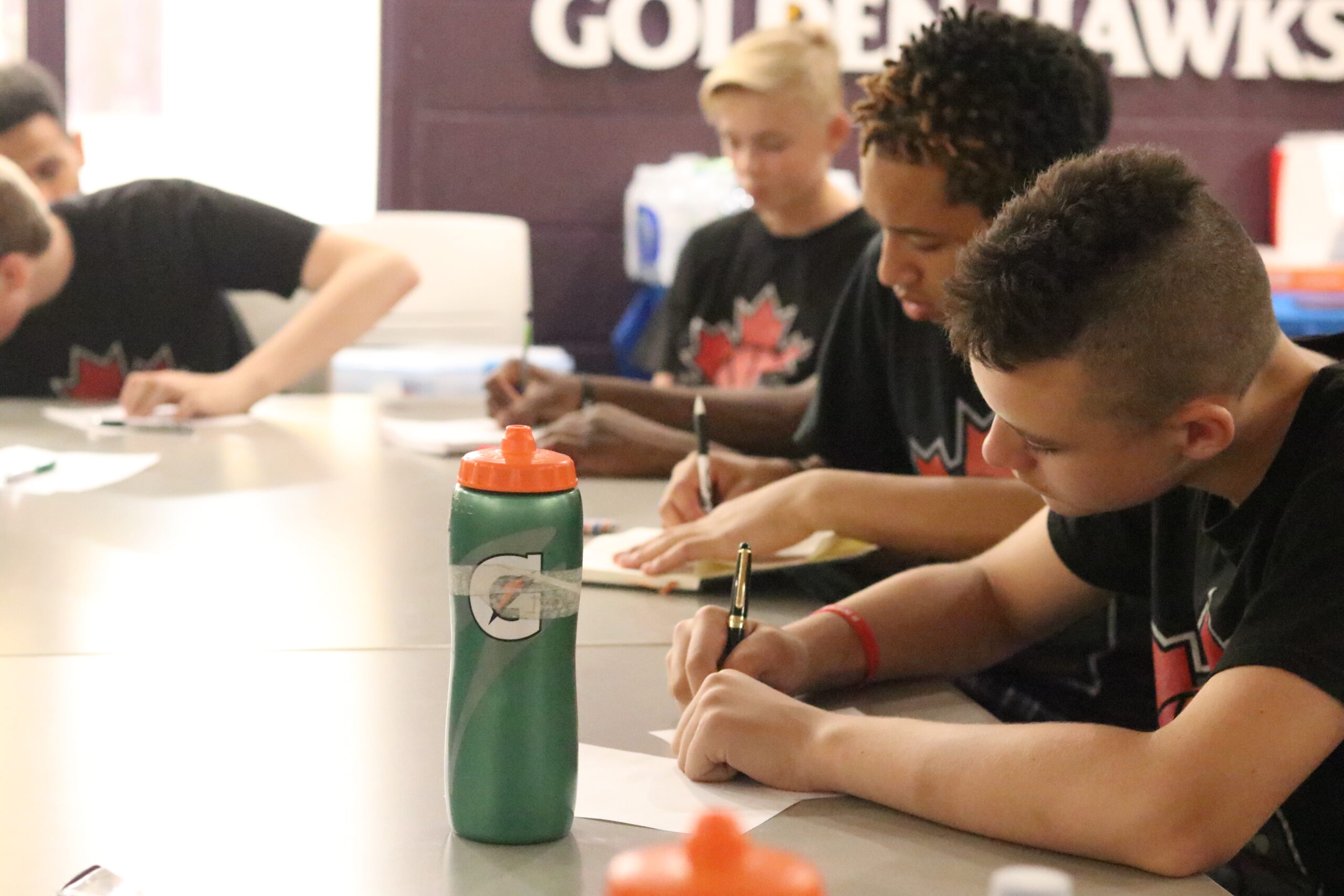 a group of boys writing notes at an NBYMP workshop